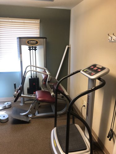 Rehabilitation area at Spine & Injury Center of Grand Junction featuring a Lordex 3000 spinal decompression machine and T-Zone vibration equipment