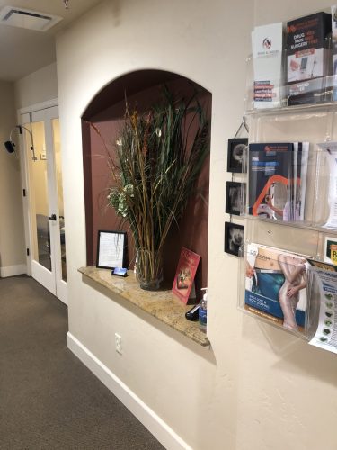 Hallway with informational brochures on spinal decompression, laser therapy, and weight loss at Spine & Injury Center of Grand Junction